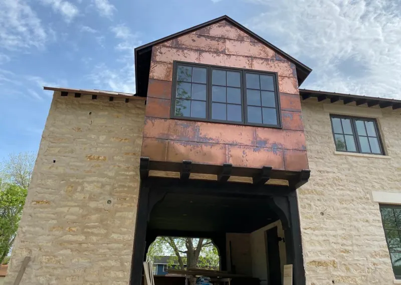 Copper metal panel facade on a stone building for Roof Repair in Cohasset